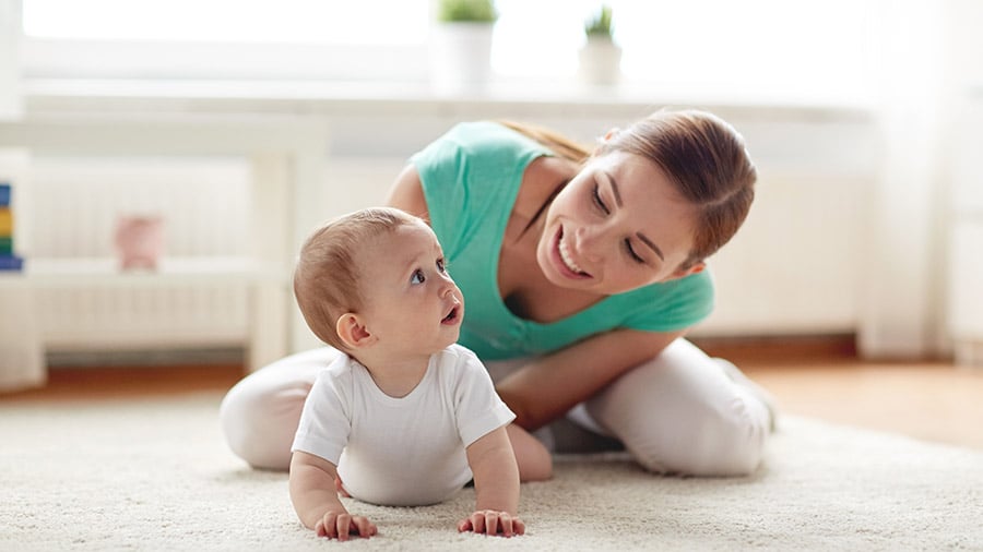 Parent playing with a baby on the floor at home